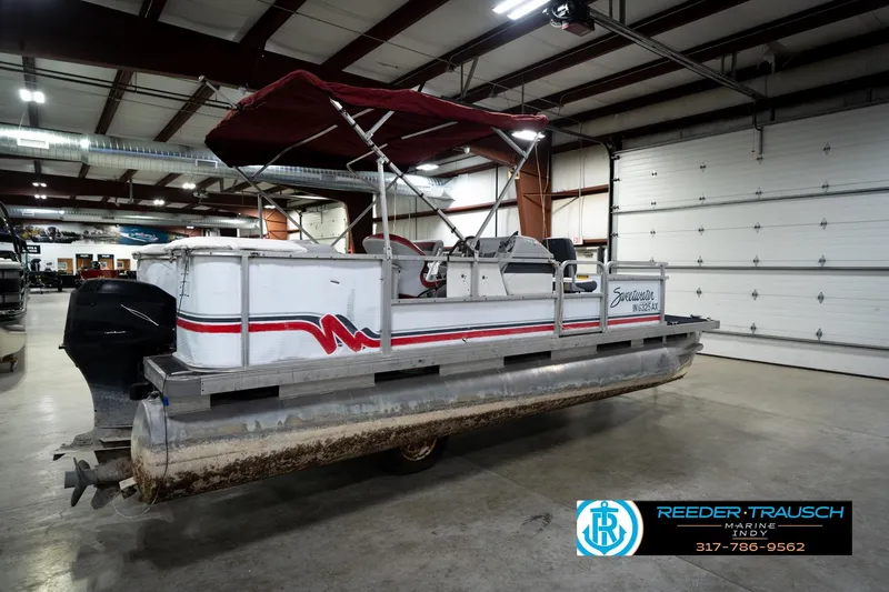 Slide: The Image of 1993 Godfrey Sweetwater pontoon boat in indoor showroom with red canopy. - 7