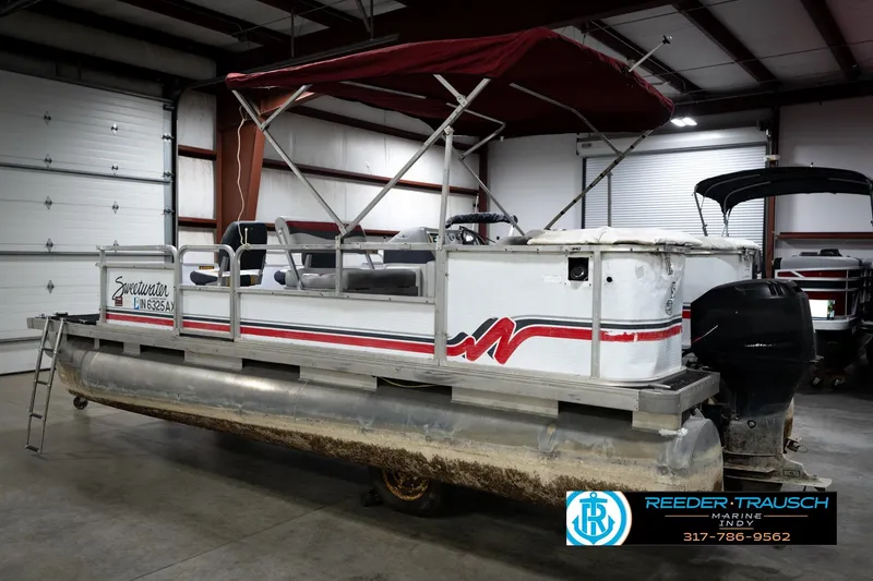 Slide: The Image of 1993 Godfrey Sweetwater pontoon boat with canopy in indoor storage facility. - 9