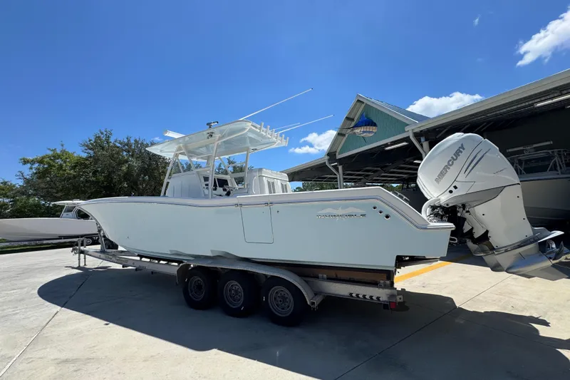 Slide: The Image of 2021 Invincible 36 Open Fisherman boat on trailer, parked outdoors under clear blue sky. - 19