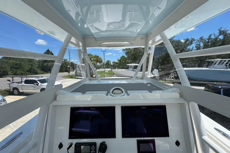 Slide: The Image of 2021 Invincible 36 Open Fisherman boat cockpit with dual screens and clear canopy. - 35