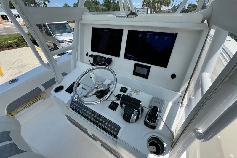Slide: The Image of 2021 Invincible 36 Open Fisherman boat console with steering wheel and navigation screens. - 36