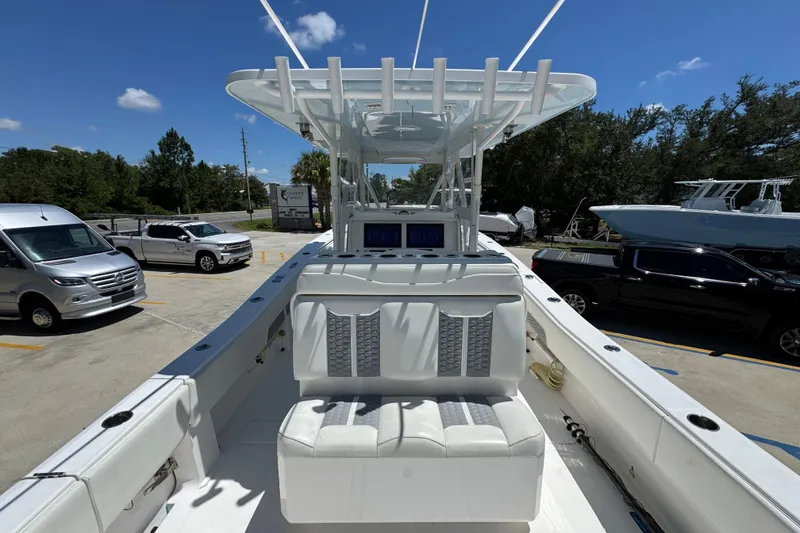 Slide: The Image of 2021 Invincible 36 Open Fisherman boat with seating, parked outdoors under clear blue sky. - 38