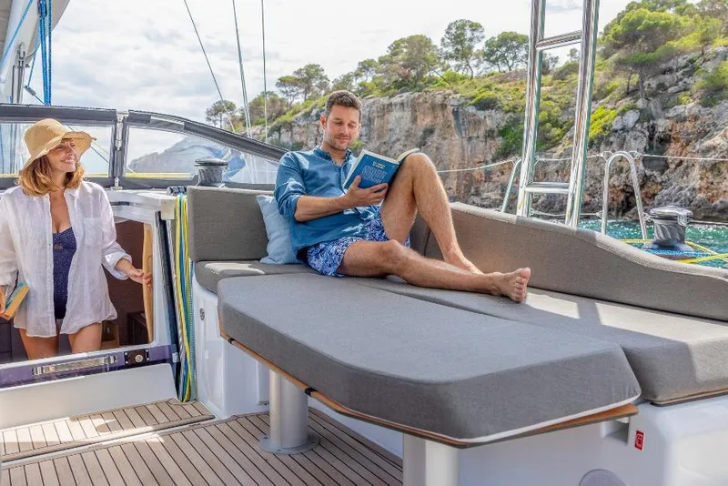 The Image of Couple relaxing on a 2026 Dufour 48 yacht, enjoying a sunny day at sea. - 0