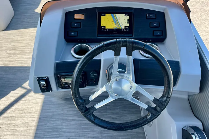 Slide: The Image of 2023 Bennington SX23 boat dashboard with steering wheel and navigation display. - 12