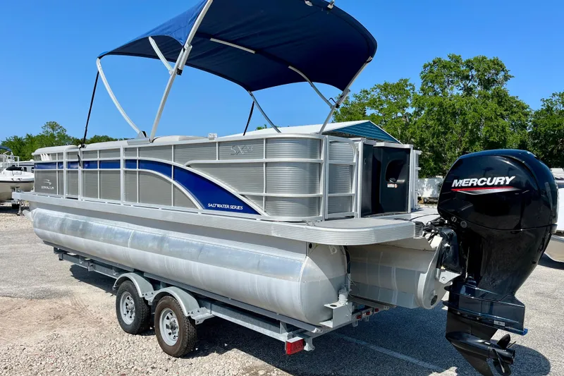 Slide: The Image of 2023 Bennington SX23 pontoon boat with Mercury engine, parked on a trailer. - 4