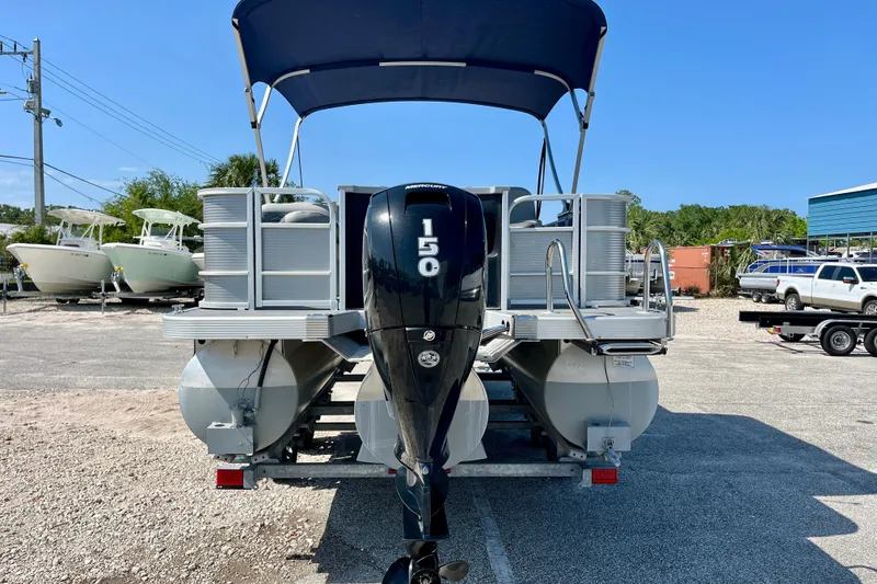 Slide: The Image of 2023 Bennington SX23 pontoon boat with 150 HP engine, parked outdoors. - 5