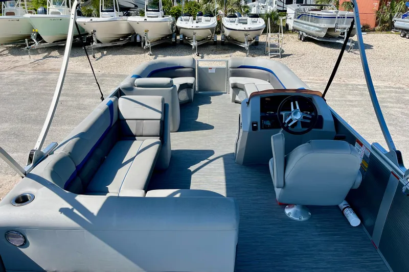 Slide: The Image of 2023 Bennington SX23 pontoon boat interior with gray seating and steering console. - 8