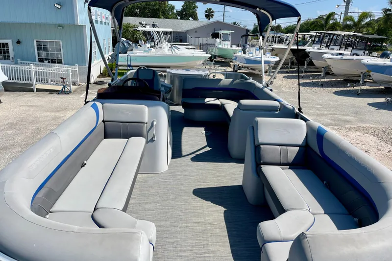 Slide: The Image of 2023 Bennington SX23 pontoon boat with spacious seating, docked at a marina. - 9
