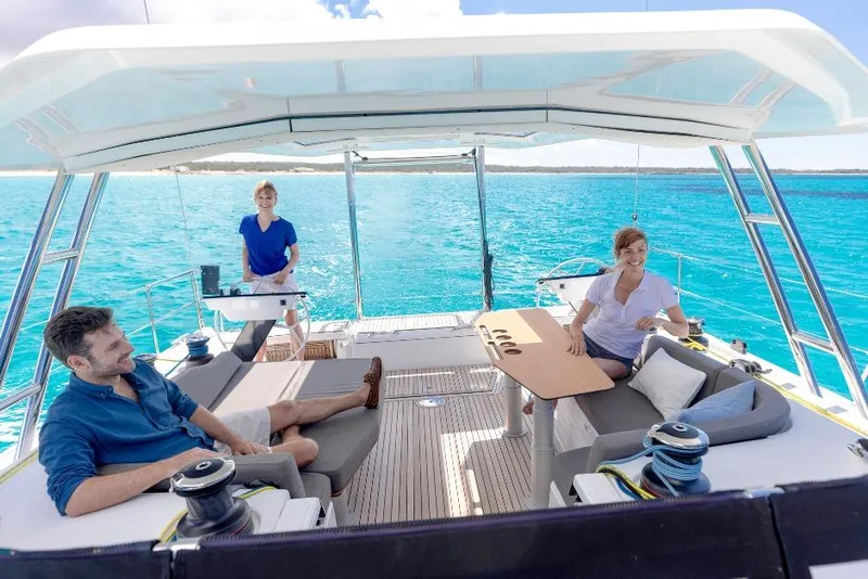 Slide: The Image of 2026 Dufour 48 yacht with people relaxing on deck, surrounded by clear blue water. - 15