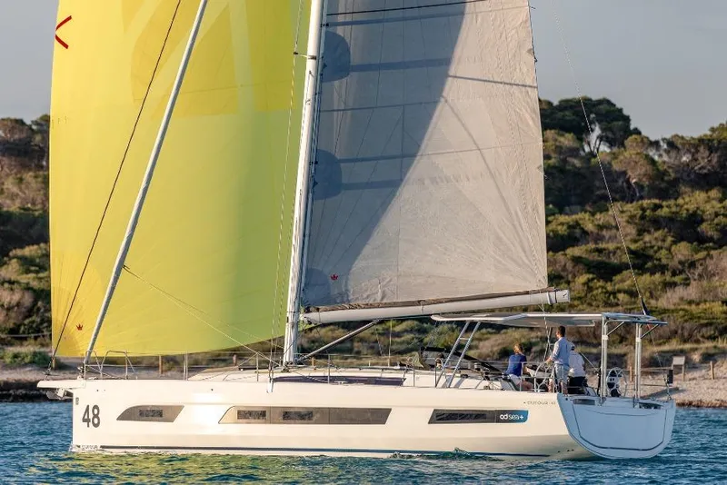 Slide: The Image of Sailing yacht Dufour 48, 2026 model, cruising on turquoise waters under cloudy skies. - 17