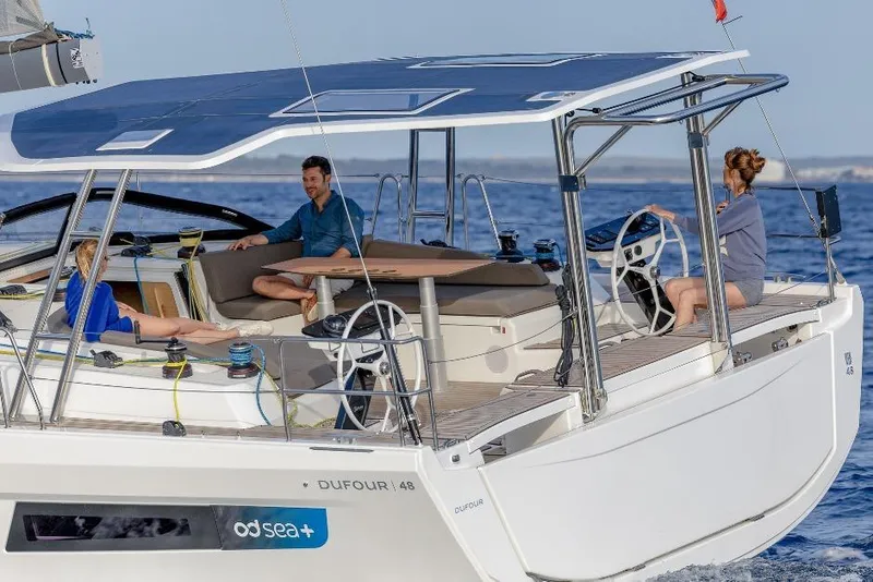 Slide: The Image of 2026 Dufour 48 sailing yacht on open sea with crew onboard. - 22