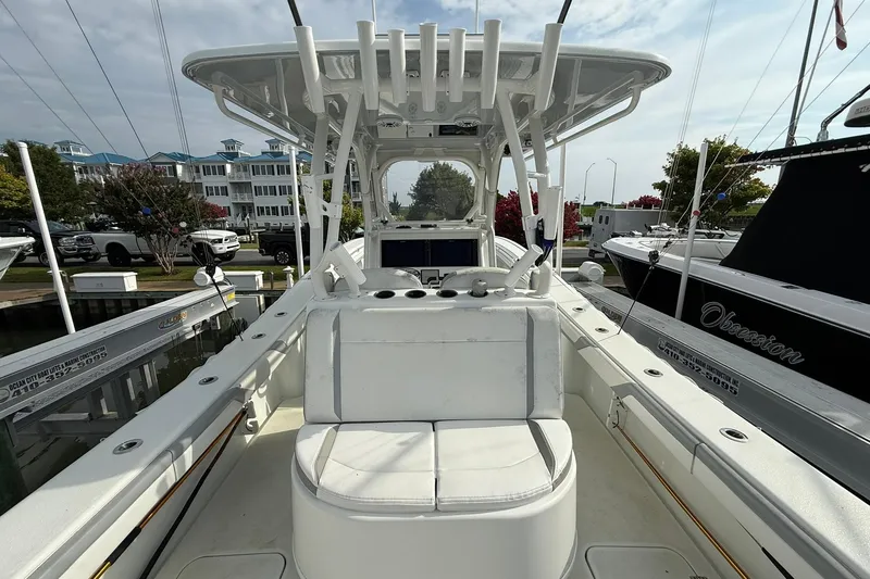 Slide: The Image of 2021 Yellowfin 36 Offshore boat interior with seating and steering wheel, docked in a marina. - 16