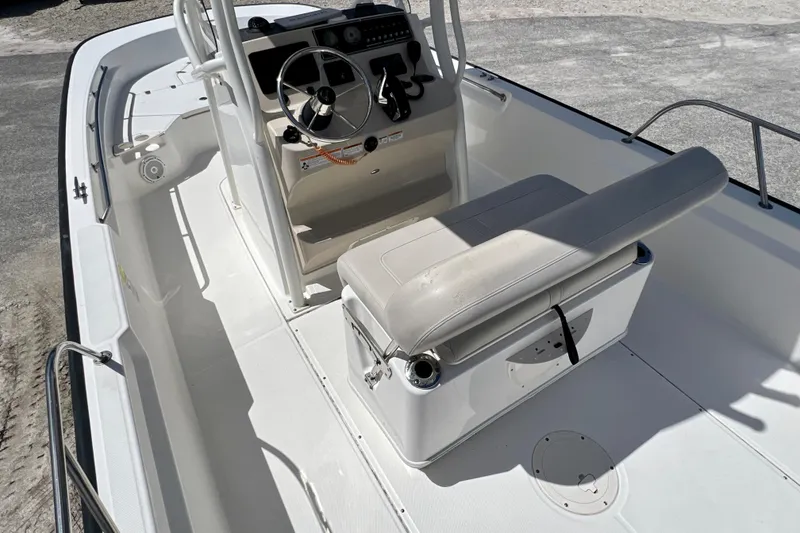 Slide: The Image of 2023 Boston Whaler 210 Montauk boat interior with steering console and cushioned seating. - 10