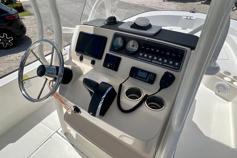 Slide: The Image of 2023 Boston Whaler 210 Montauk boat console with steering wheel and controls. - 12