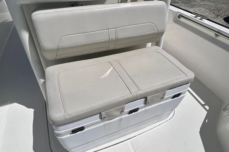 Slide: The Image of 2023 Boston Whaler 210 Montauk boat seat with cushioned backrest and storage compartment. - 18