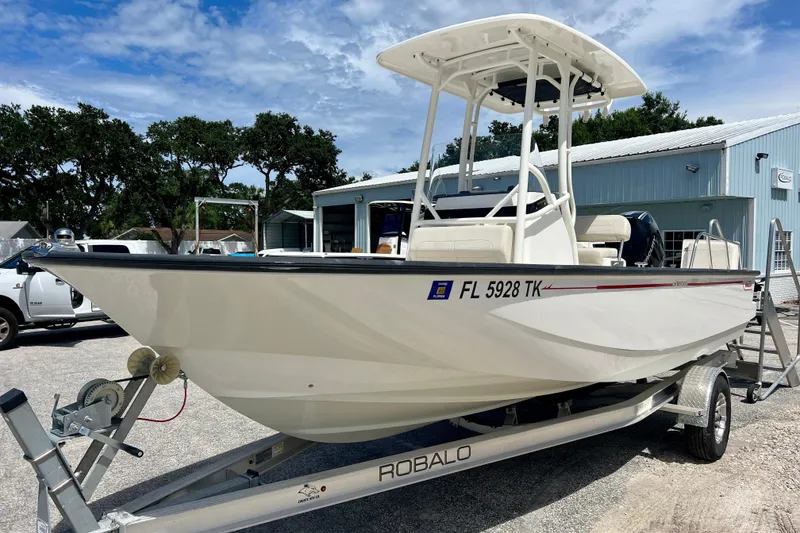 Slide: The Image of 2023 Boston Whaler 210 Montauk boat on trailer, parked outdoors near a building. - 4
