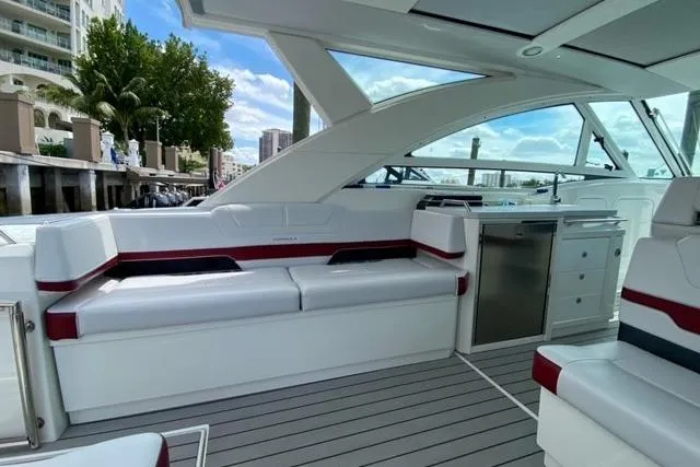 Slide: The Image of 2020 Formula 430 Super Sport Crossover boat cruising on calm water near a dock. - 13