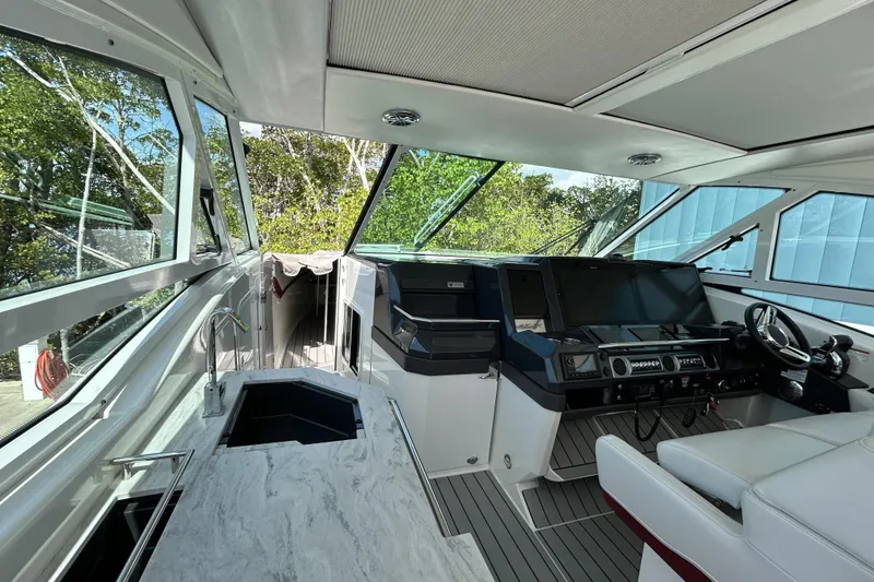 Slide: The Image of 2020 Formula 430 Super Sport Crossover boat on calm water, surrounded by trees. - 14