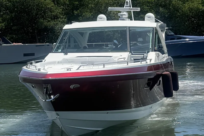 Slide: The Image of 2020 Formula 430 Super Sport Crossover yacht docked near a lighthouse. - 2