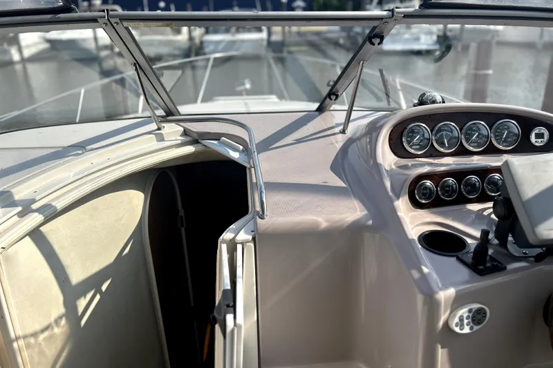 Slide: The Image of 2001 Regal Commodore 2960 boat dashboard with gauges and open cabin door. - 10