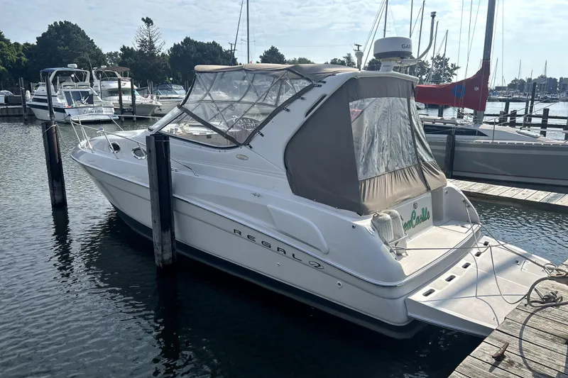 Slide: The Image of 2001 Regal Commodore 2960 boat docked at marina, featuring sleek design and covered cockpit. - 2