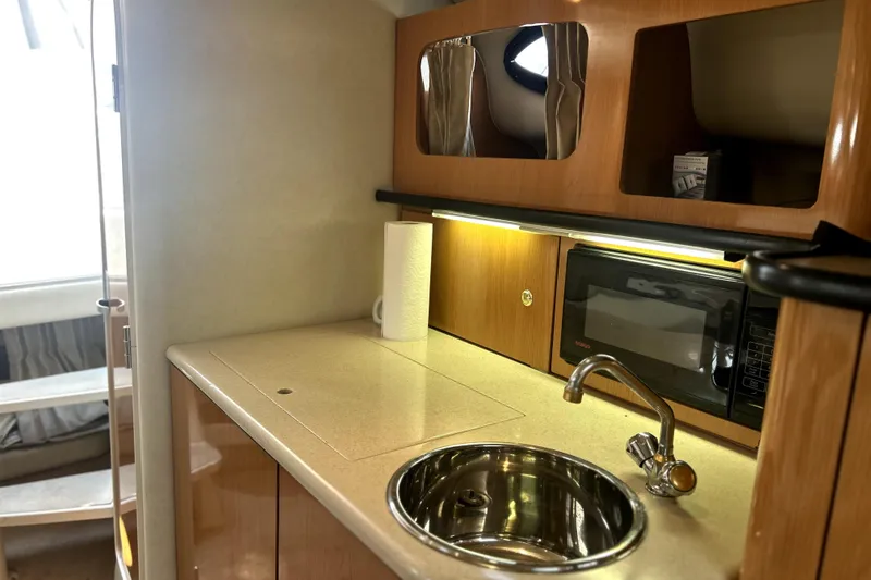 Slide: The Image of 2001 Regal Commodore 2960 boat interior with kitchenette, sink, and microwave. - 25