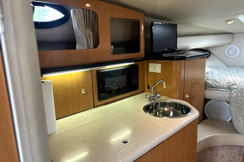 Slide: The Image of 2001 Regal Commodore 2960 yacht interior with kitchenette, sink, and cozy sleeping area. - 26