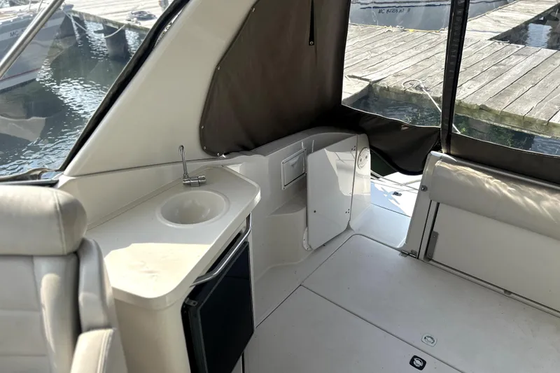 Slide: The Image of 2001 Regal Commodore 2960 boat interior with sink, seating, and dock view. - 5
