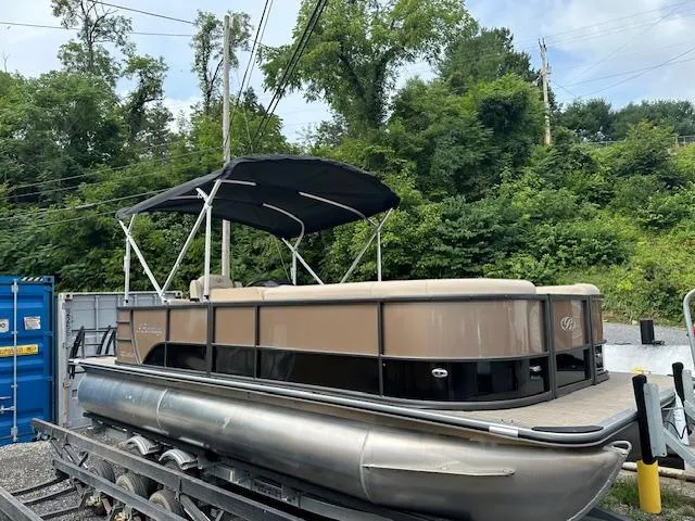 Slide: The Image of 2025 Bentley Pontoons 220 Cruise XL pontoon boat with canopy in a storage yard. - 0