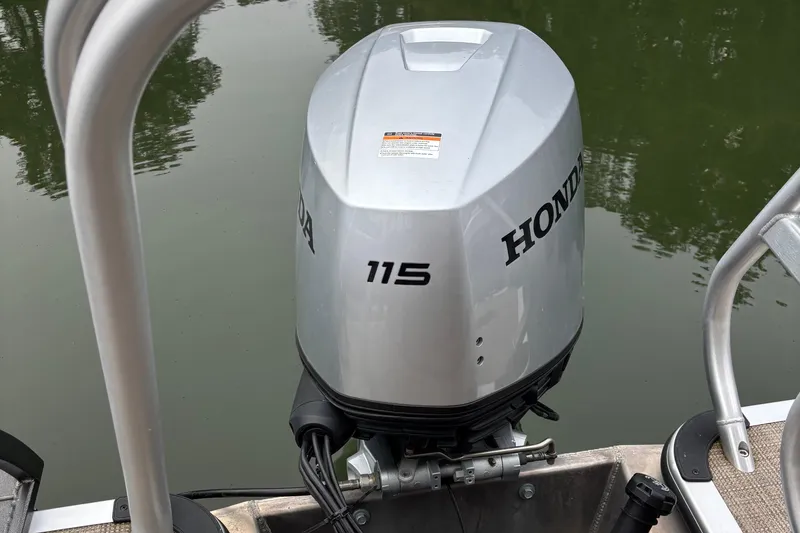 Slide: The Image of Honda 115 outboard motor on 2025 Bentley Pontoons 220 Cruise XL, docked on calm water. - 10