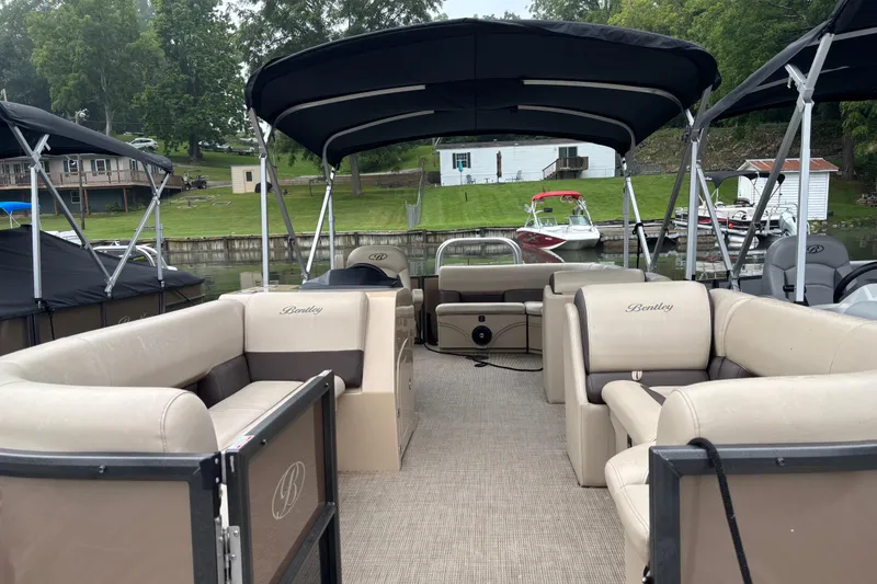 Slide: The Image of 2025 Bentley Pontoons 220 Cruise XL with spacious seating and canopy, docked by a lakeside. - 4