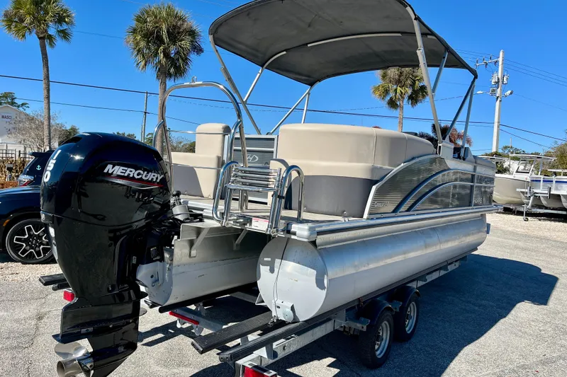 Slide: The Image of 2023 Harris Cruiser 230 pontoon boat with Mercury engine on trailer, sunny day. - 26