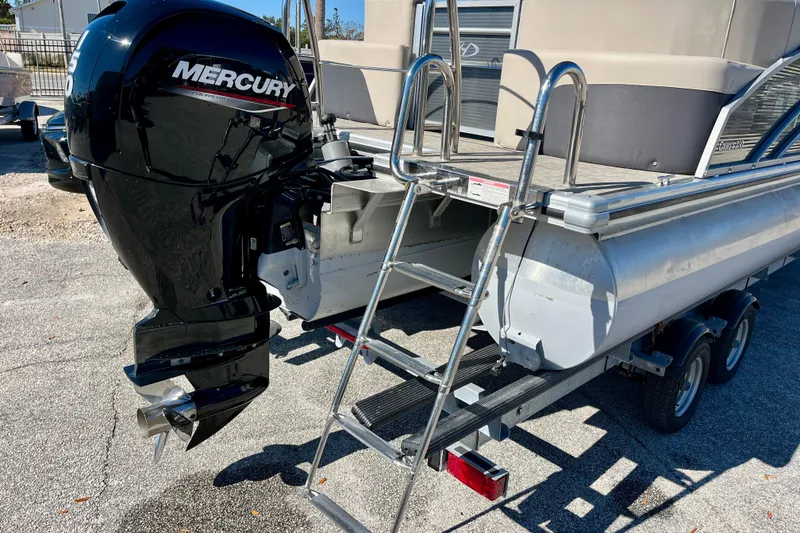 Slide: The Image of 2023 Harris Cruiser 230 pontoon boat with Mercury outboard motor and boarding ladder. - 28