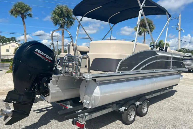 Slide: The Image of 2023 Harris Cruiser 230 boat seating with storage compartment, featuring light gray upholstery. - 7