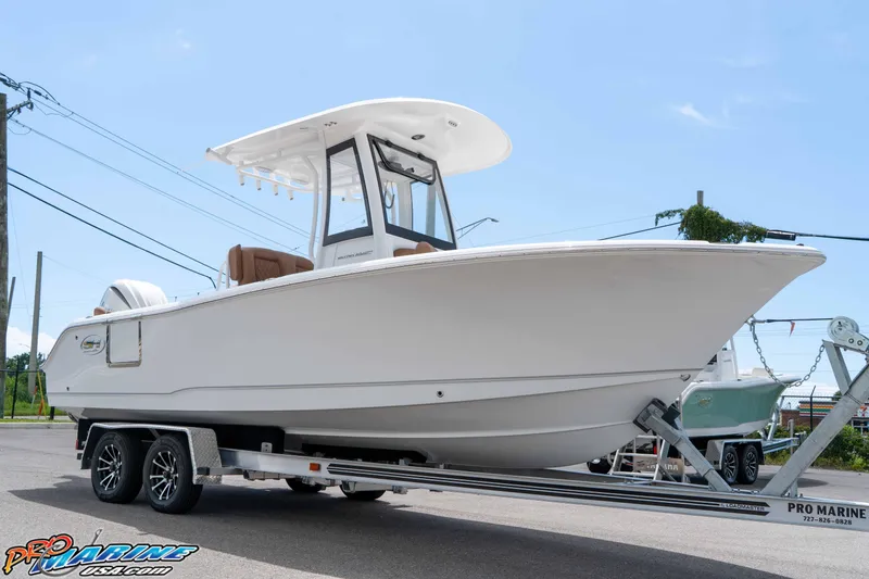 Slide: The Image of 2025 Sea Hunt Ultra 235 SE boat on trailer, displayed outdoors. - 18