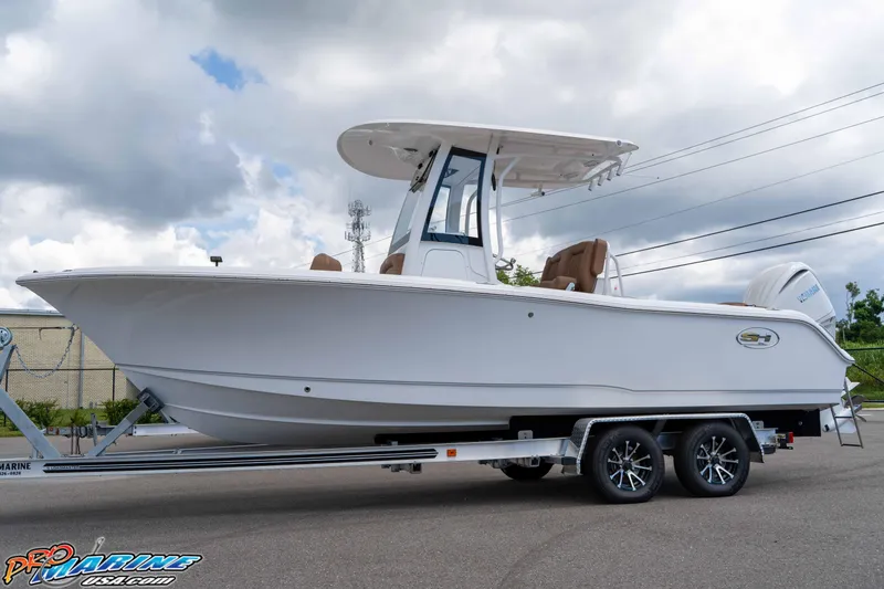Slide: The Image of 2025 Sea Hunt Ultra 235 SE boat on trailer, under cloudy sky. - 23