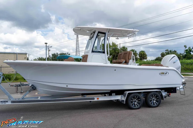 Slide: The Image of 2025 Sea Hunt Ultra 235 SE boat on trailer, parked outdoors under cloudy sky. - 24
