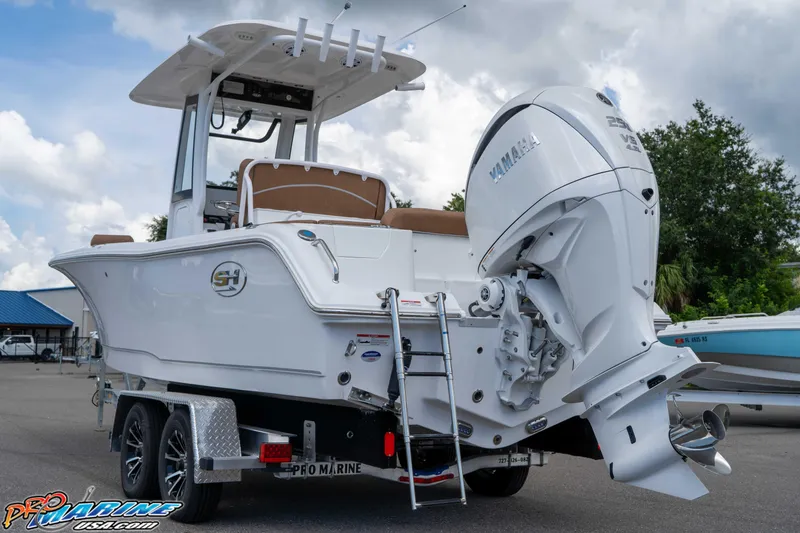 Slide: The Image of 2025 Sea Hunt Ultra 235 SE boat with Yamaha engine on trailer, outdoor display. - 25
