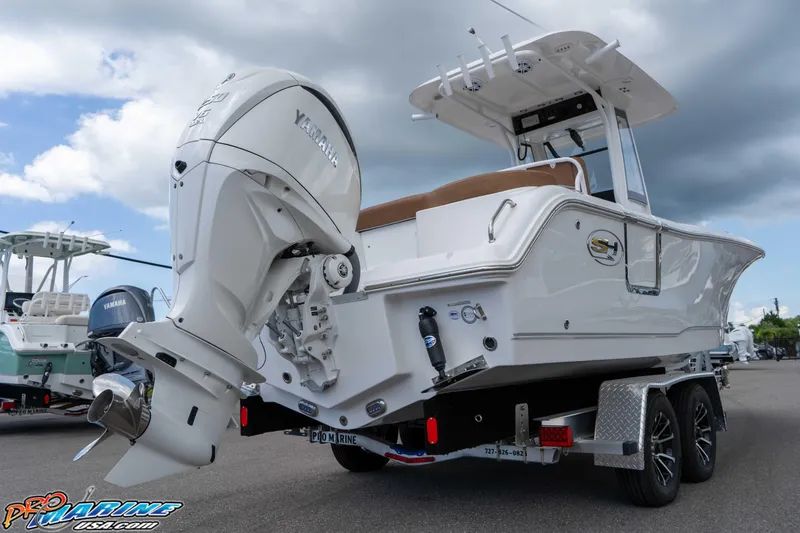 Slide: The Image of 2025 Sea Hunt Ultra 235 SE boat with Yamaha engine on trailer, under cloudy sky. - 28