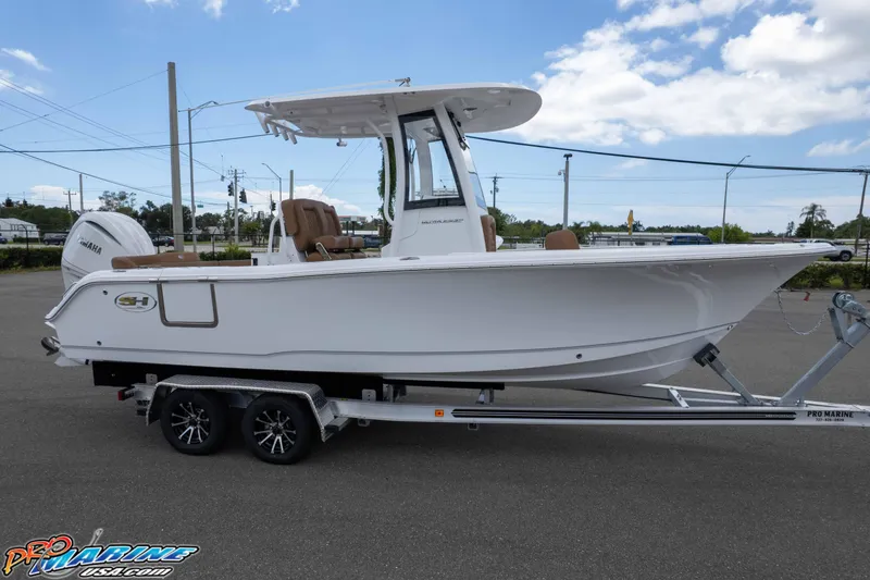 Slide: The Image of 2025 Sea Hunt Ultra 235 SE boat on trailer, parked outdoors under blue sky. - 3