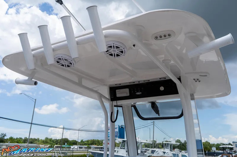 Slide: The Image of 2025 Sea Hunt Ultra 235 SE boat with rod holders and speakers under a cloudy sky. - 38