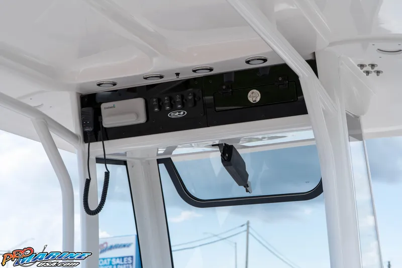 Slide: The Image of 2025 Sea Hunt Ultra 235 SE boat console with Garmin electronics and overhead storage. - 39