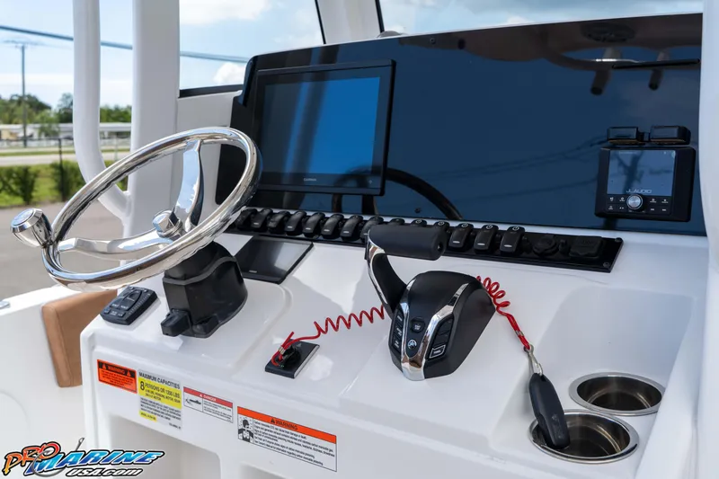 Slide: The Image of Control panel of 2025 Sea Hunt Ultra 235 SE boat with steering wheel and electronics. - 40