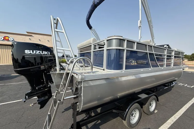 Slide: The Image of 2026 Landau Island Breeze 21 C pontoon boat with Suzuki outboard motor on trailer. - 5