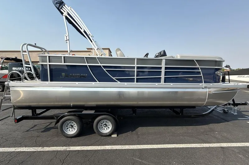Slide: The Image of 2026 Landau Island Breeze 21 C pontoon boat on a trailer in a parking lot. - 6