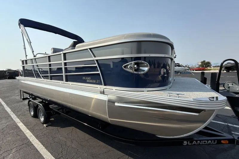 Slide: The Image of 2026 Landau Island Breeze 21 C pontoon boat on trailer, parked outdoors. - 7