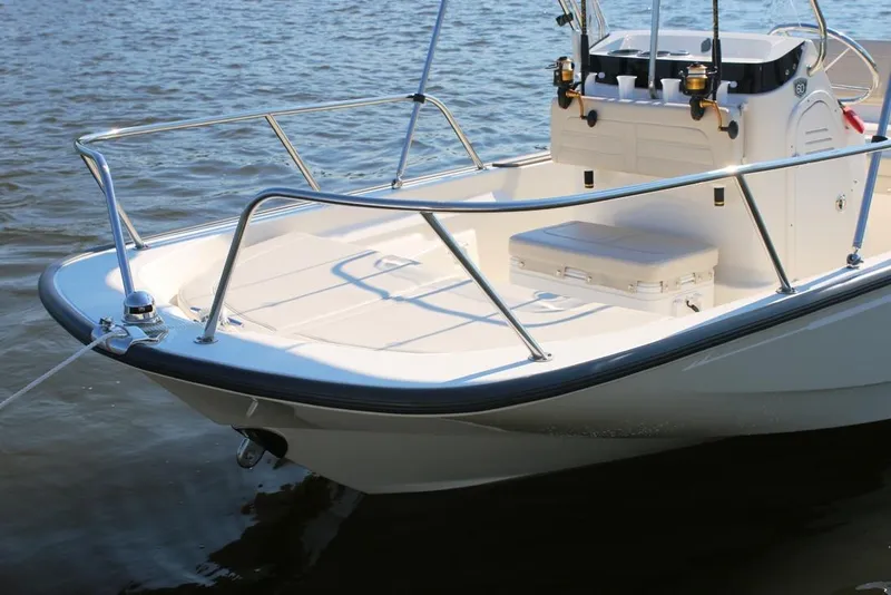 Slide: The Image of 2022 Boston Whaler 150 Montauk boat on calm water, showcasing sleek design and spacious deck. - 17