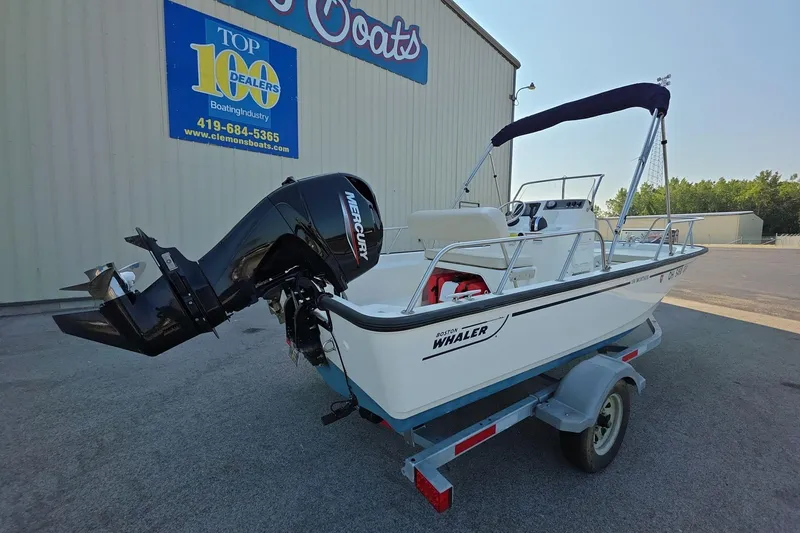 Slide: The Image of 2022 Boston Whaler 150 Montauk boat on trailer, displayed outside dealership. - 3