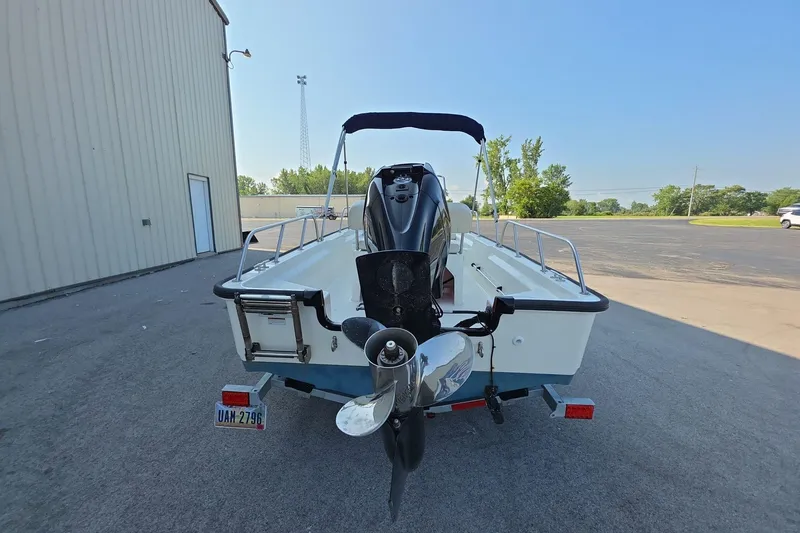 Slide: The Image of 2022 Boston Whaler 150 Montauk boat on trailer, rear view, outdoors. - 4