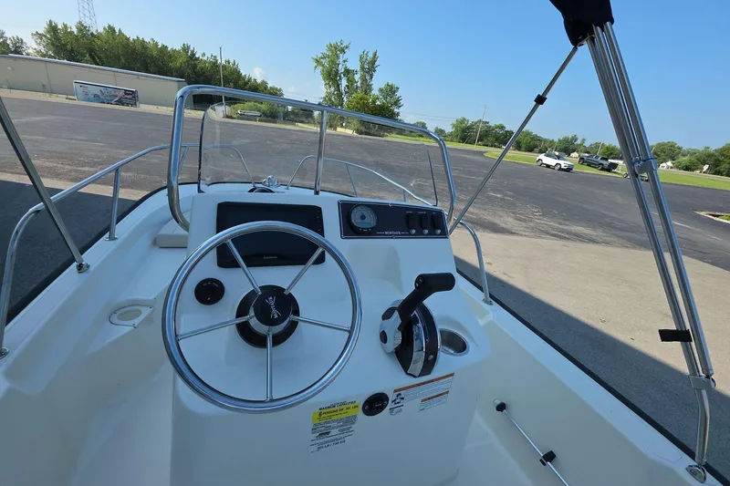 Slide: The Image of 2022 Boston Whaler 150 Montauk boat dashboard with steering wheel and controls. - 6